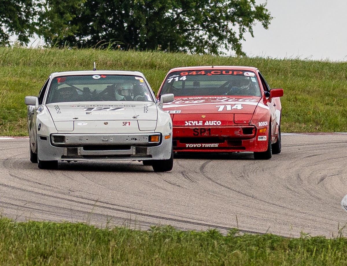 White and red FuelLine Racing cars rounding a racetrack turn